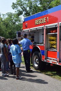 A fireman shows youth the equipment on one of the rescue vehicles