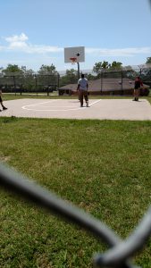 MCH resident plays ball with staff on the newly painted basketball court.