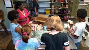 Direct care staff Mrs. Talia assists a few of our girls as they package beans at Christian Community Action in Ruston for distribution from their food pantry.